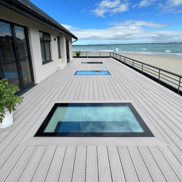 Modern deck with skylight windows overlooking beach, showcasing sustainable outdoor design.