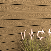 Close-up of teak composite cladding beside ornamental grass