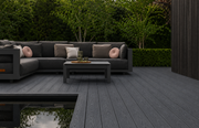 Dark grey composite decking beside outdoor sofas and a reflecting pond