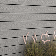 Close-up of light grey composite cladding beside ornamental grass