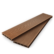 Stacked coffee composite decking boards showing woodgrain and grooved faces