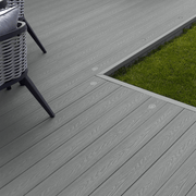 Dark Grey composite decking laid beside a lawn