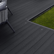 Charcoal composite decking laid beside a lawn